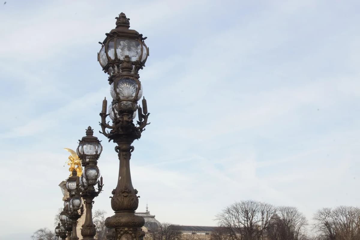 Ornate 19th-century lamppost in Paris against a pale sky, evoking the city where Adam Mickiewicz lived in political exile