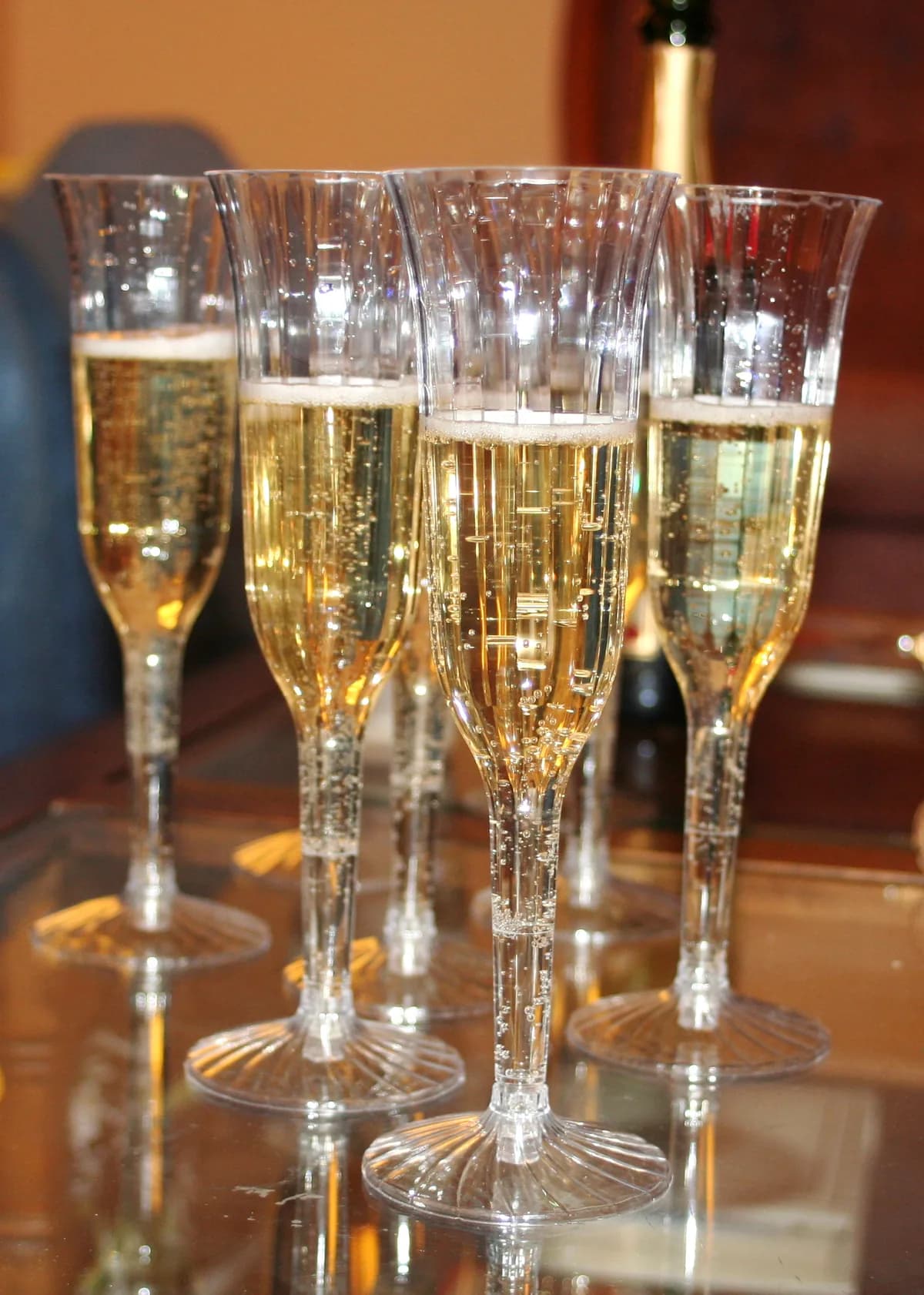 Several champagne flutes filled with sparkling wine, arranged on a table and ready for a toast