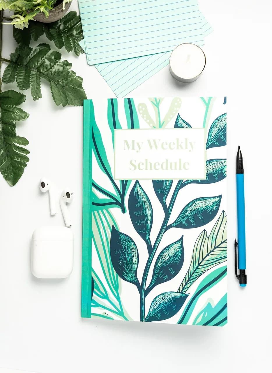 A planner and notes used to organize a self-study routine, with earbuds nearby for listening practice