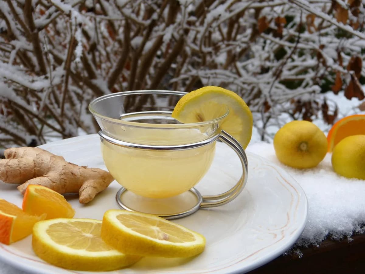 A cup of hot tea with lemon and ginger served in the snow, the traditional way Polish winter swimmers warm back up