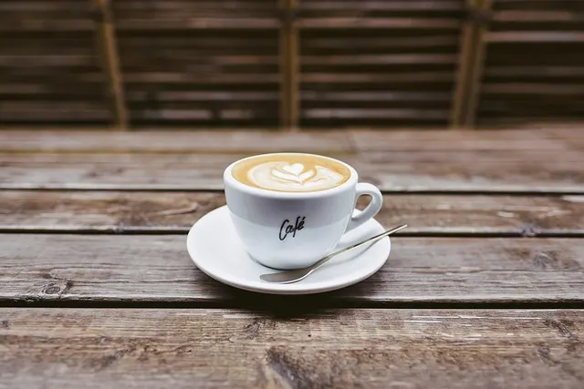 A latte on a wooden cafe table — coffee shops are one of the most relaxed corners of napiwek etiquette