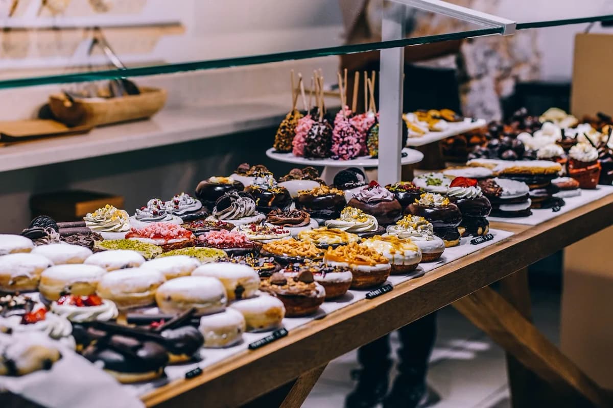 A Polish bakery display case filled with rows of glazed and filled paczki