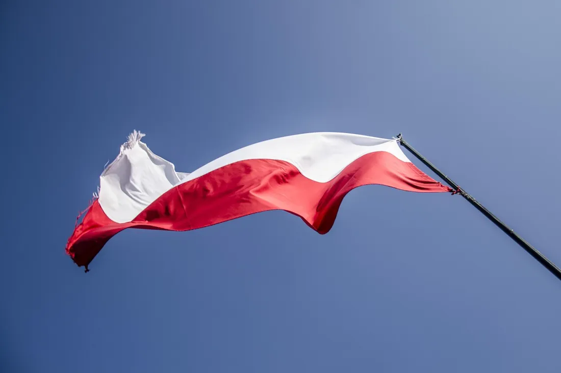 A Polish flag flying against a clear blue sky, representing the language the Polish alphabet was built to write