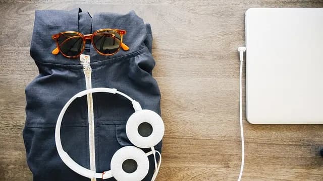 White headphones resting next to an open laptop, ready for a listening session