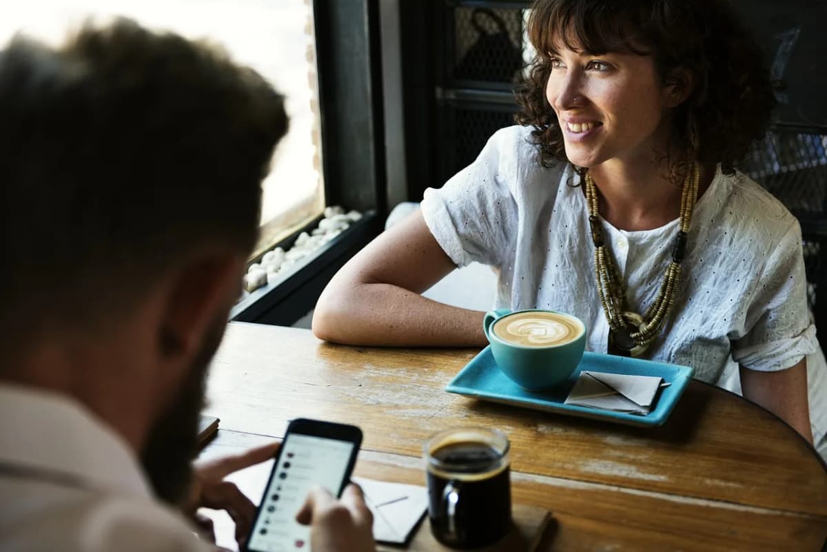 Two people chatting over coffee at a café table