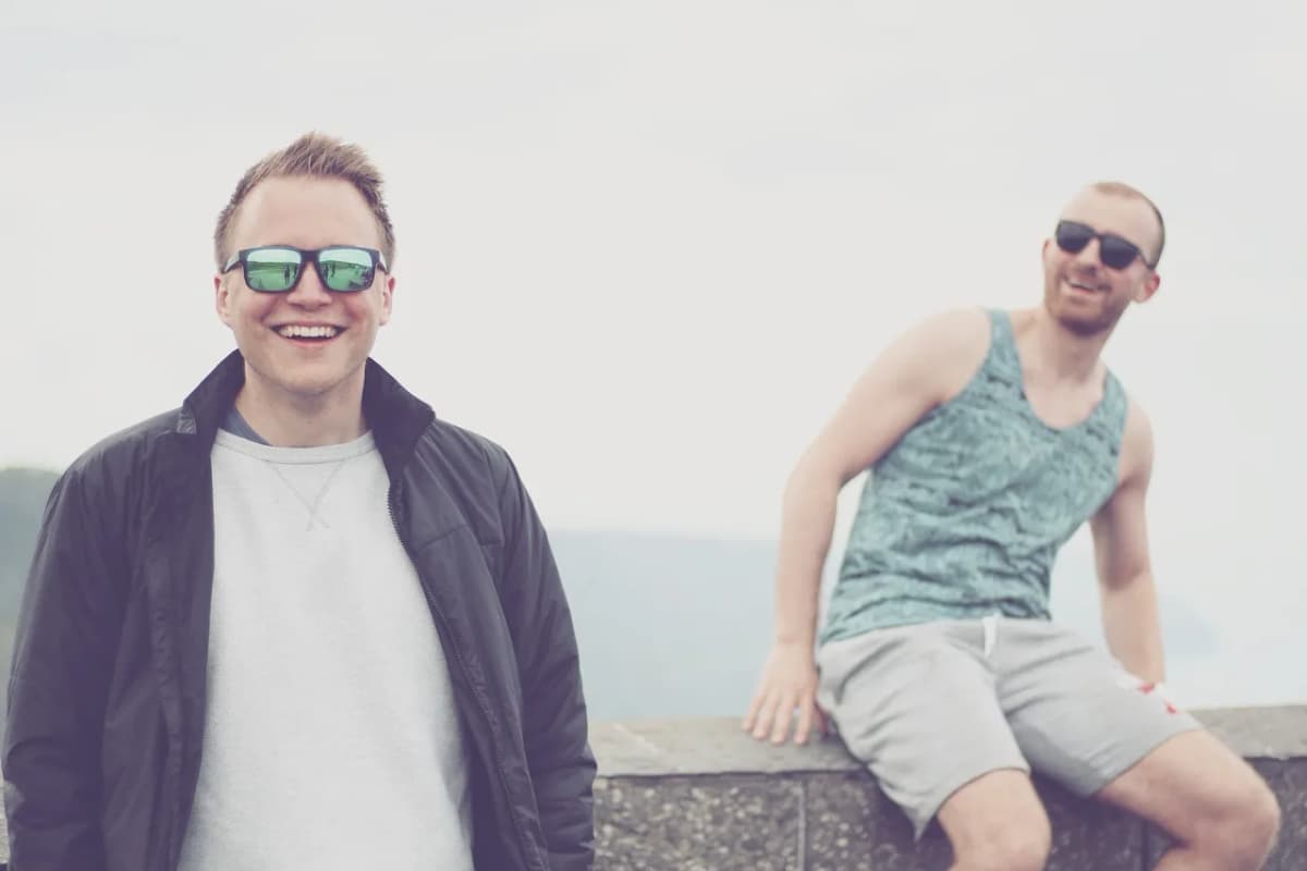 Two young friends laughing together outdoors, the kind of setting where Polish slang gets used constantly