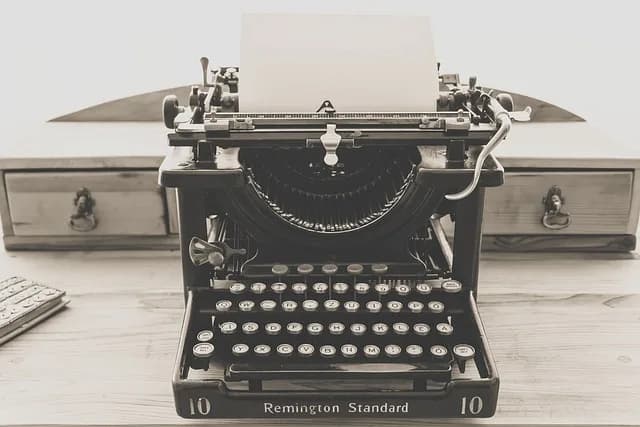 Vintage typewriter with blank paper loaded, representing the act of writing a completed piece of text