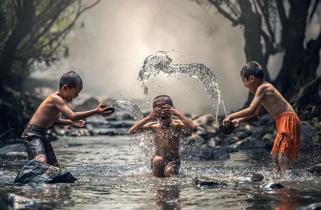 Children playfully splashing water outdoors, evoking the water-throwing customs of Smigus-Dyngus
