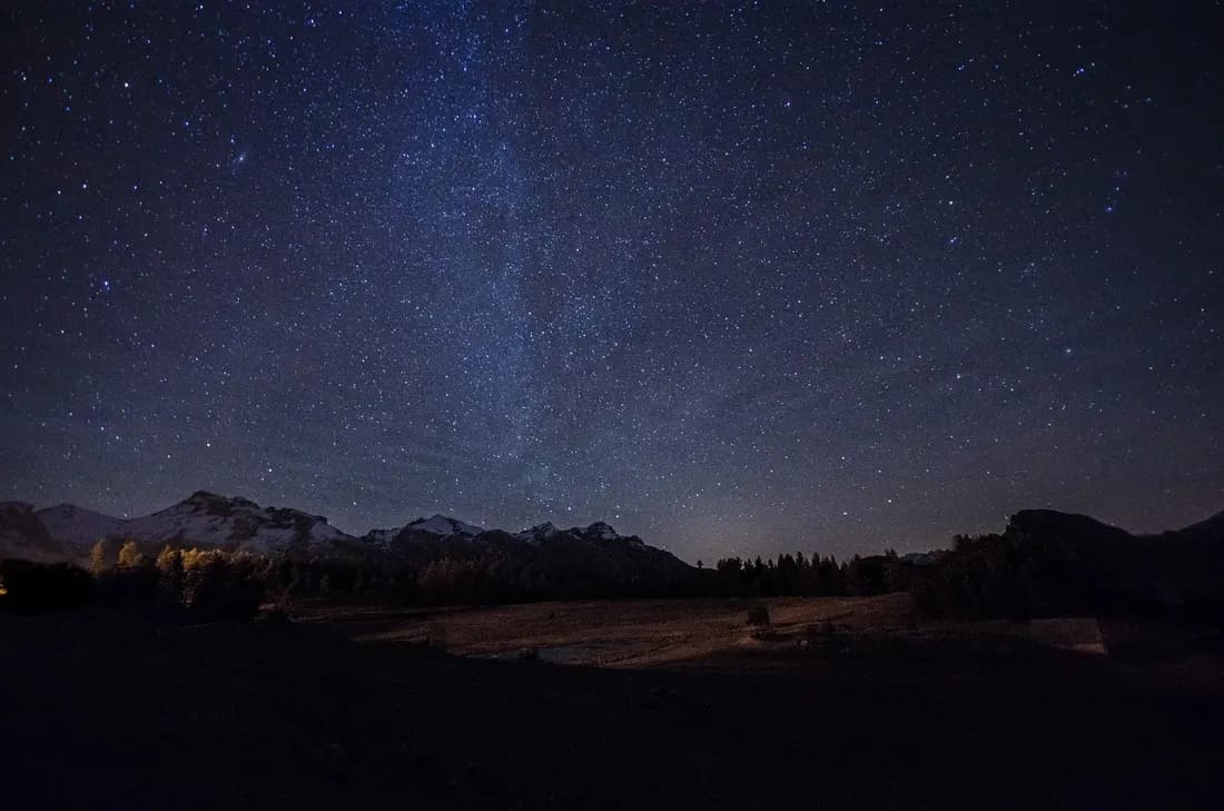 A snow-covered mountain peak under a clear night sky