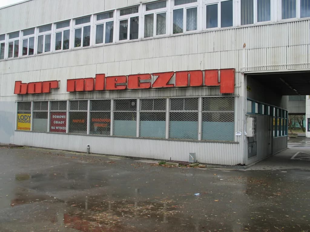 The exterior of a bar mleczny in Łódź, Poland, with a large red bar mleczny sign
