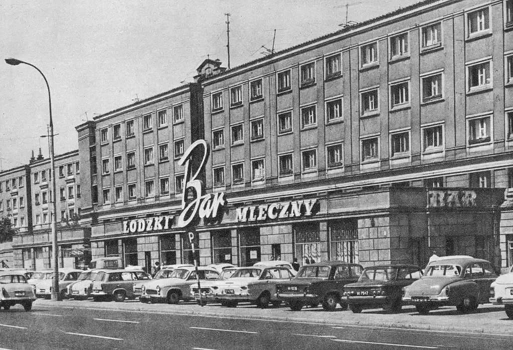 A black-and-white archival photograph from around 1971 showing the "Bar Mleczny Łódzki" cafeteria storefront on a busy Warsaw street lined with parked cars