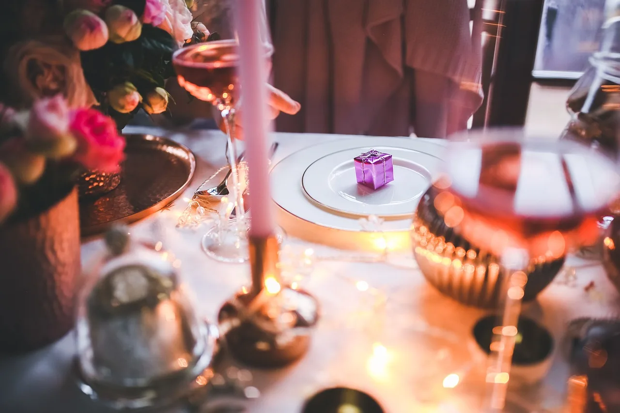 An elegantly set holiday table with candles and a small wrapped gift