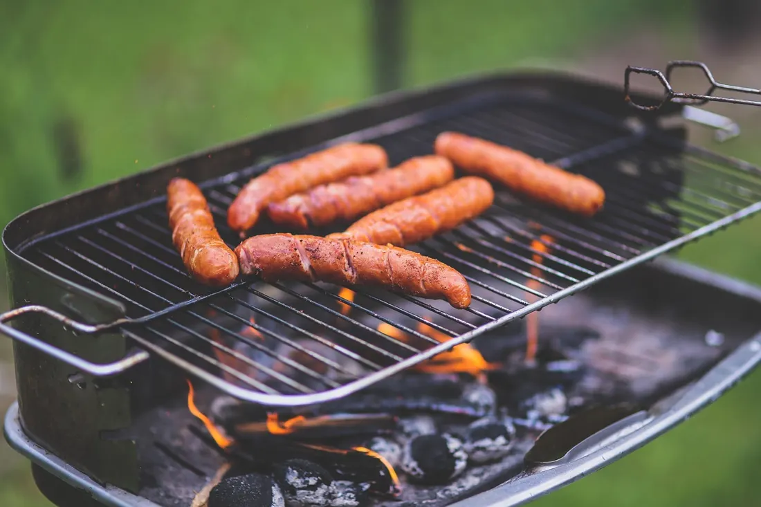 Kielbasa sausages grilling over an open charcoal fire, a popular way to prepare it at American cookouts