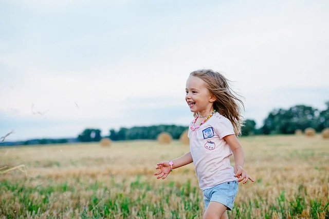 Child running joyfully through a summer meadow, evoking childhood and Polish given names