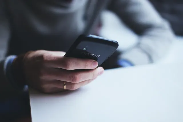 A person holding a smartphone in one hand, about to type